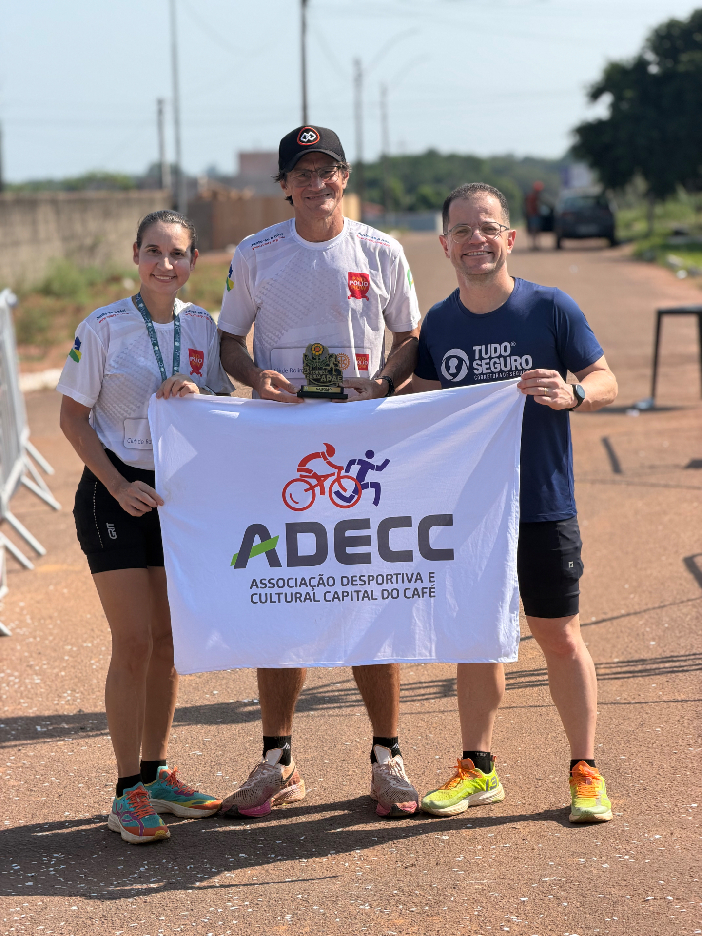 Membros da ADECC segurando a bandeira durante uma corrida