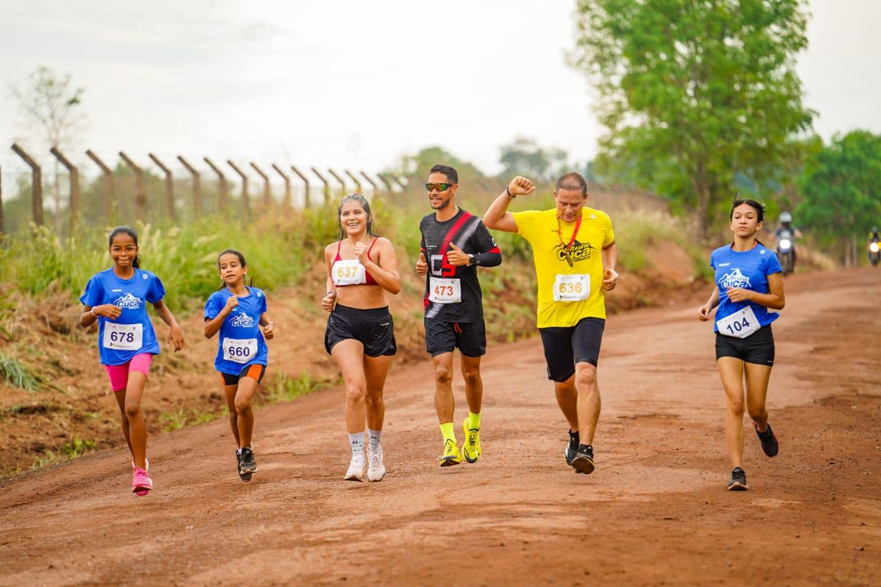 Corredores adultos e crianças em estrada de terra